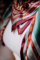 Close-up of a colorful patterned sill scarf draped over a person's shoulder.